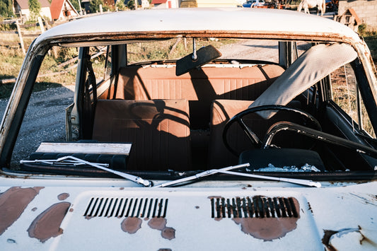 Abandoned rusty car with broken windshield